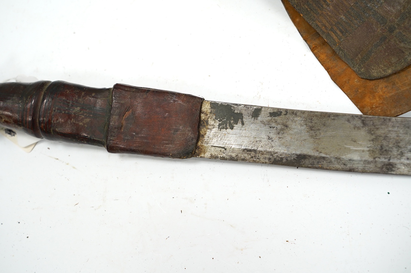 A late 19th century Nigerian Taboura from the Hausa People of Northern Nigeria, in leather scabbard, blade 59.5cm. Condition - good